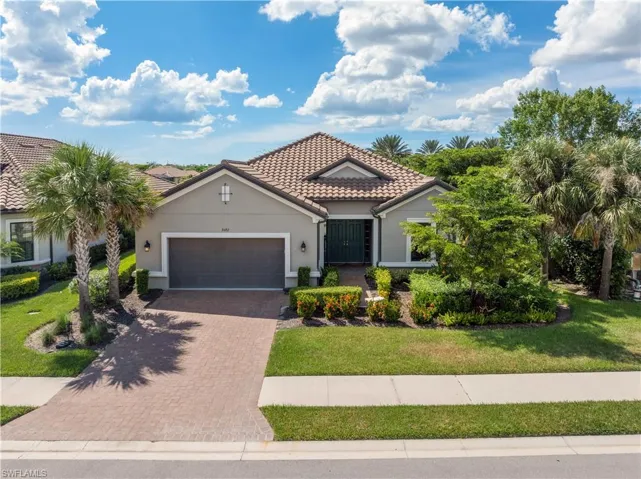 Mediterranean / spanish-style home with a garage and a front lawn