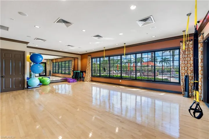 Exercise room featuring light wood-type flooring and ornamental molding