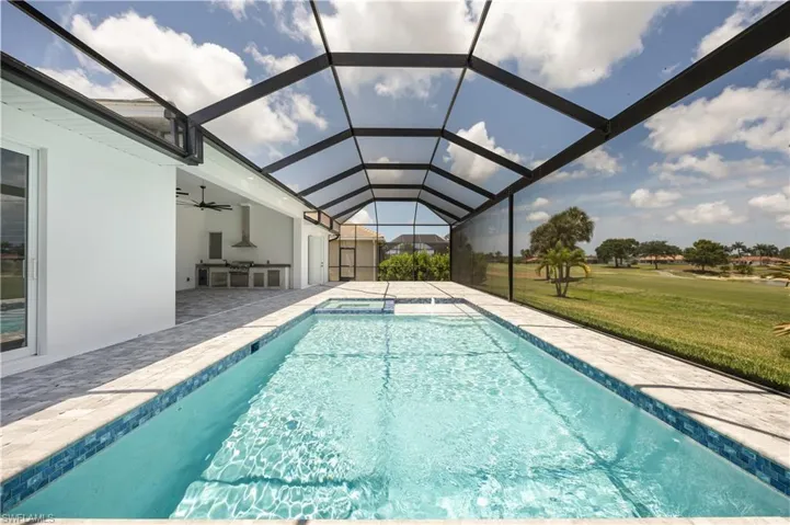 Swimming pool featuring a sunroom, a yard, ceiling fan, a patio area, and glass enclosure