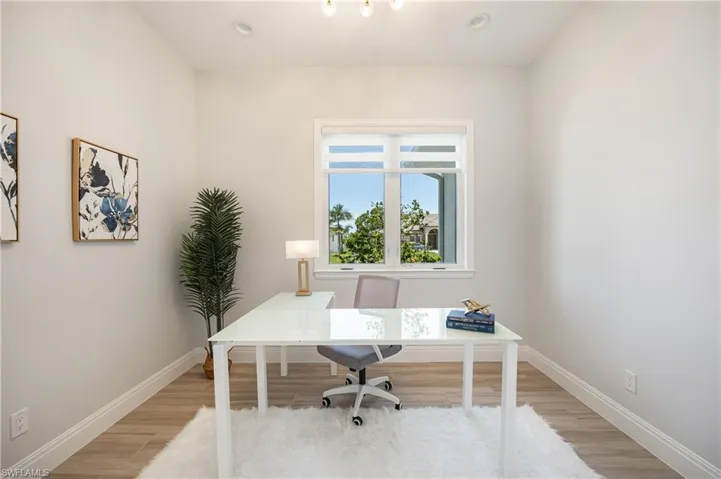 Home office with light wood-style flooring and recessed lighting