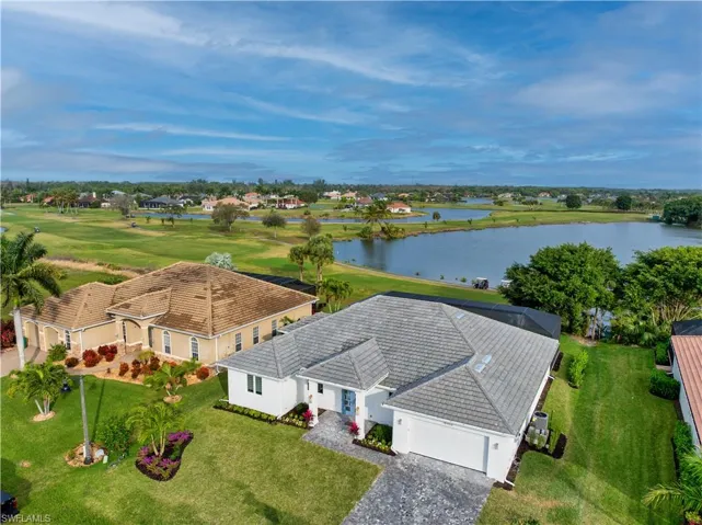 Aerial perspective of suburban area with a large body of water and a golf course