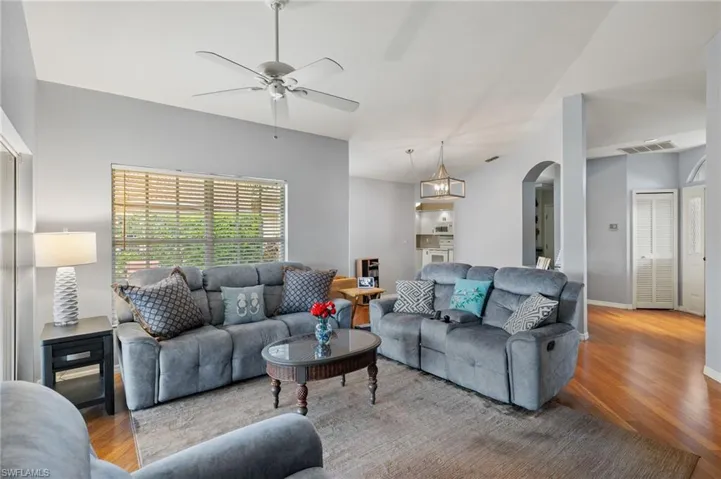 Living room with ceiling fan and hardwood / wood-style floors