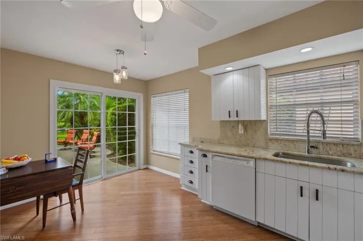 Kitchen with white cabinets, dishwasher, light hardwood / wood-style flooring, sink, and tasteful backsplash