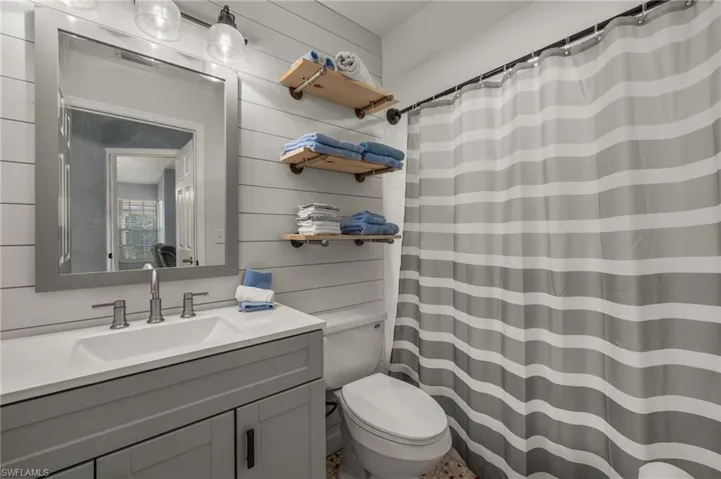 Bathroom featuring vanity, toilet, and a shower with shower curtain