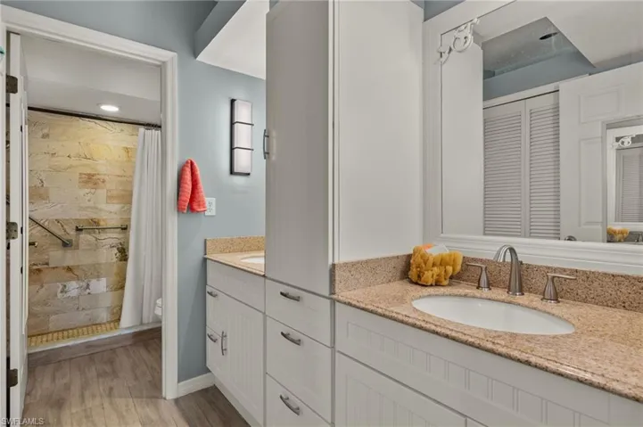 Bathroom featuring vanity, toilet, curtained shower, and hardwood / wood-style flooring