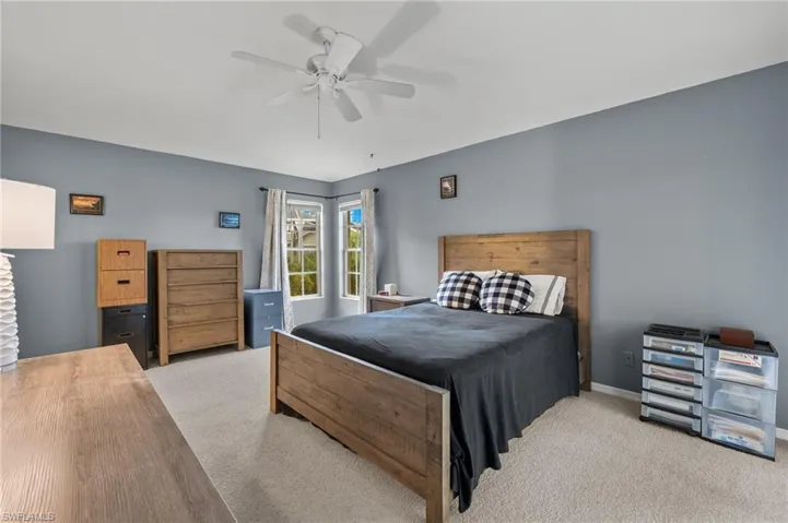 Bedroom with ceiling fan and light carpet
