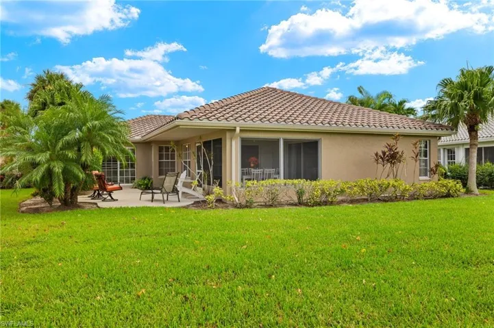 Back of house with a yard and a patio