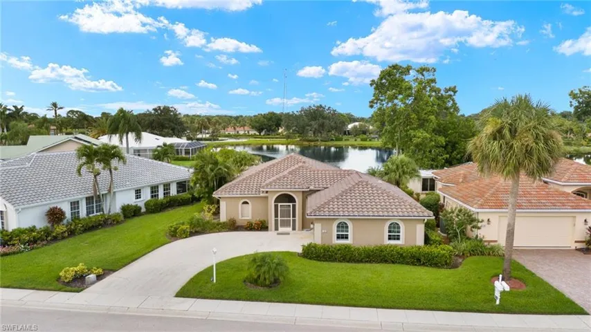 Mediterranean / spanish home featuring a water view, a front lawn, and a garage