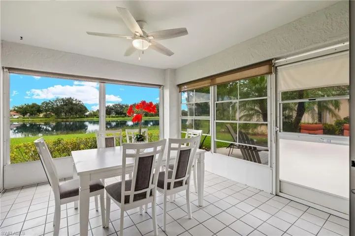 Unfurnished sunroom with ceiling fan and a water view
