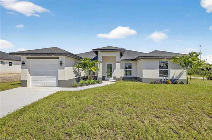 Prairie-style house featuring stucco siding, a front lawn, a garage, and concrete driveway