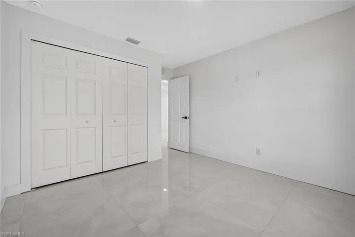 Unfurnished bedroom featuring light tile patterned flooring and a closet