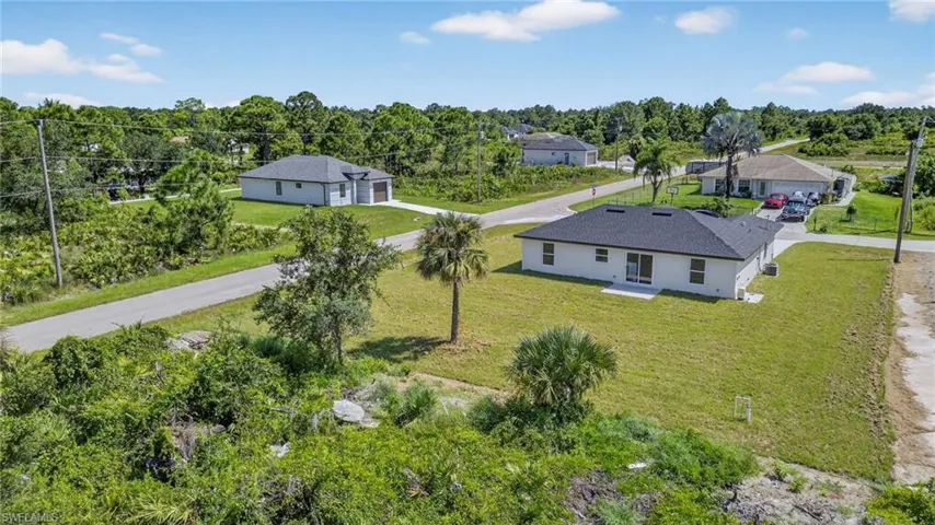 Aerial view of property and surrounding area with a tree filled landscape
