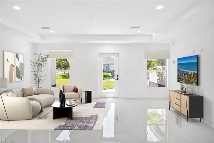 Living area with recessed lighting, light tile patterned flooring, and a raised ceiling