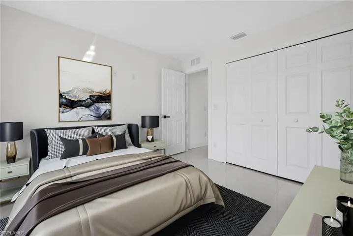 Bedroom featuring light tile patterned floors and a closet