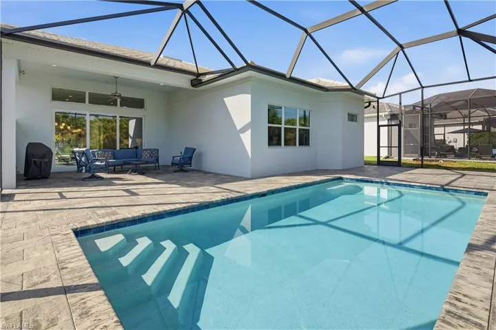 Swimming pool with a sunroom, a lanai, outdoor lounge area, a patio area, and area for grilling