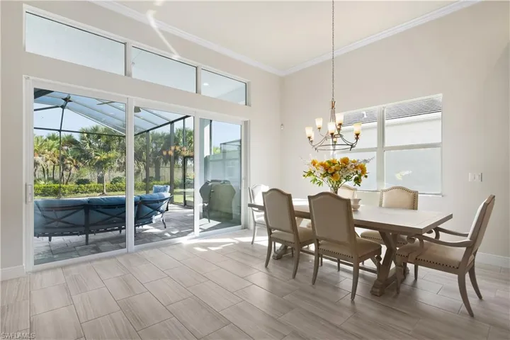 Dining area featuring a sunroom, ornamental molding, wood tiled floors, and a chandelier