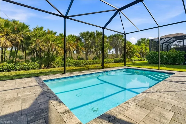 Swimming pool with a sunroom, glass enclosure, a yard, and a patio area