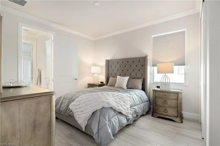 Bedroom featuring ornamental molding and wood tiled floors