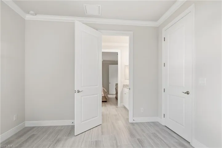 Unfurnished bedroom with crown molding and light wood-style floors