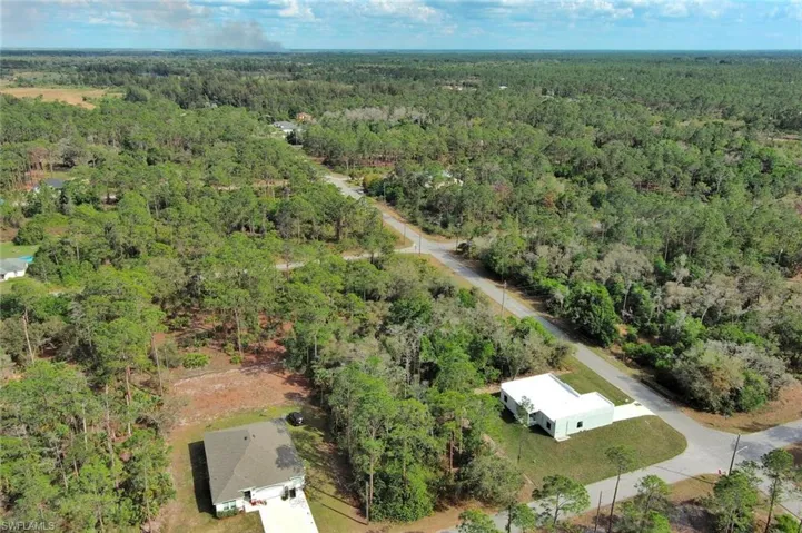 Aerial view of property's location featuring a forest