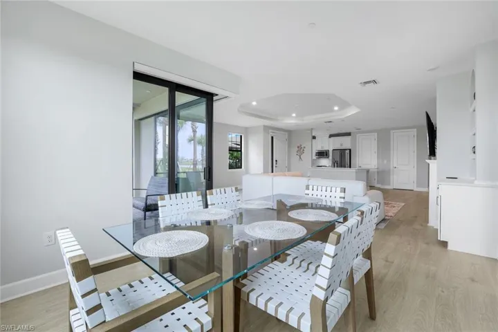 Dining area featuring a raised ceiling and light wood finished floors