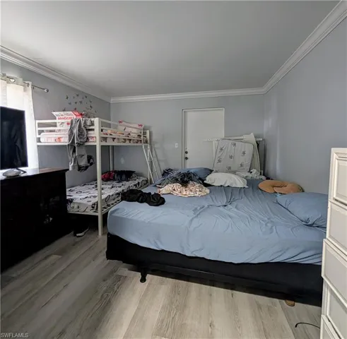 Bedroom featuring crown molding and light flooring