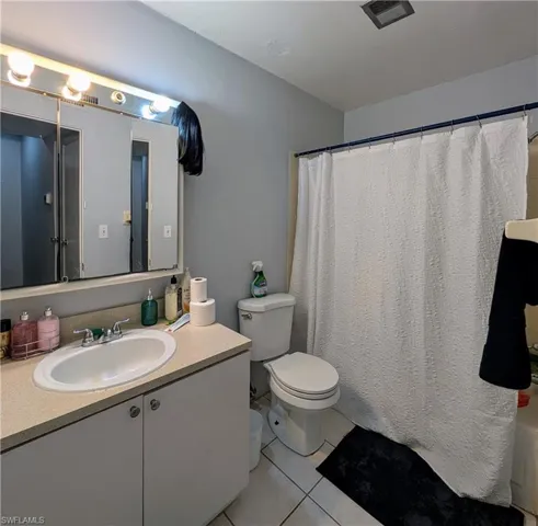 Bathroom featuring tile flooring, vanity, and toilet