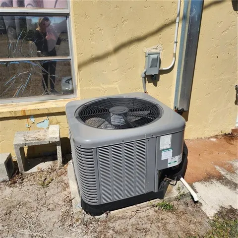 Exterior wall featuring an installed air conditioning unit