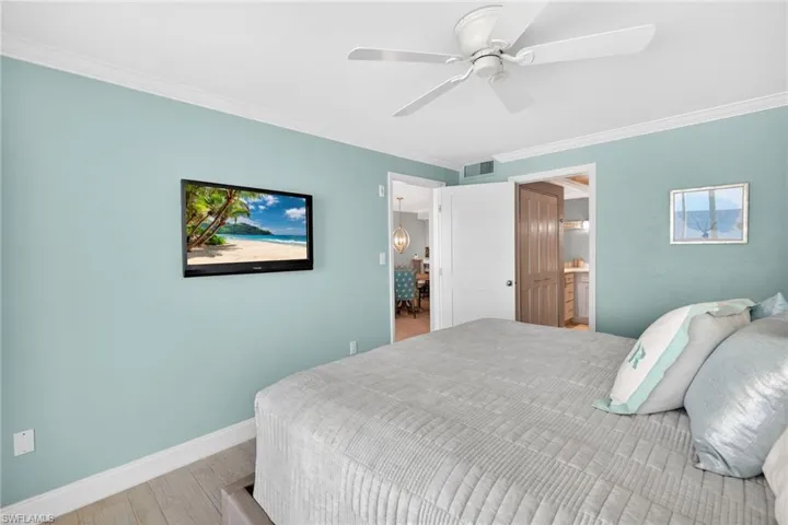 Bedroom featuring ornamental molding, wood finished floors, and ceiling fan