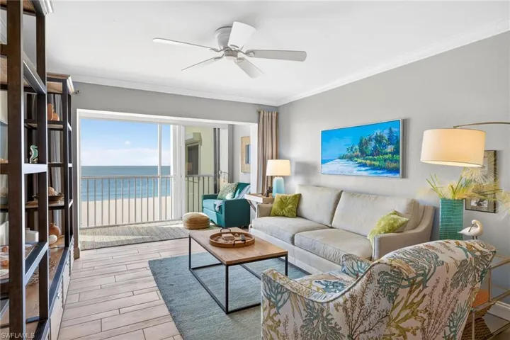Living area featuring crown molding, a water view, wood tiled floors, and a ceiling fan