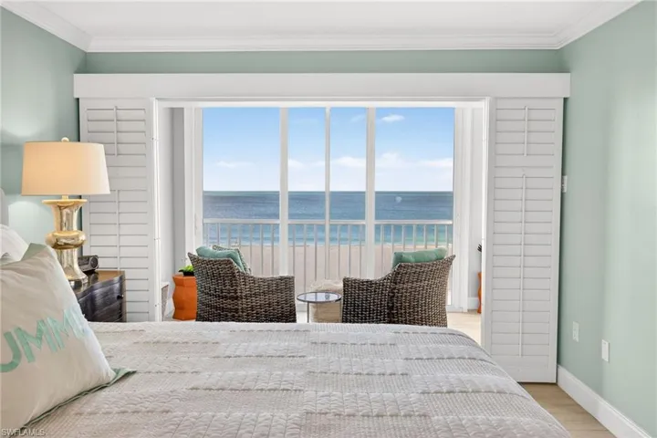 Bedroom featuring crown molding, a water view, light wood finished floors, multiple windows, and access to exterior