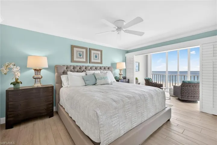 Bedroom featuring crown molding, a water view, light wood finished floors, access to outside, and a ceiling fan