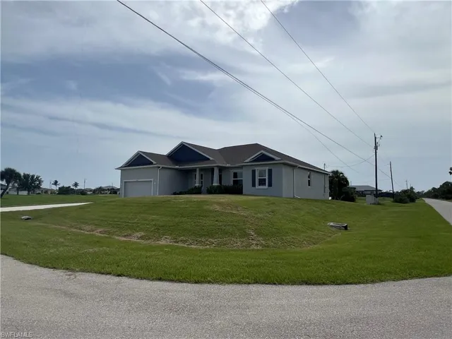 Ranch-style house with an attached garage, a front yard, and stucco siding