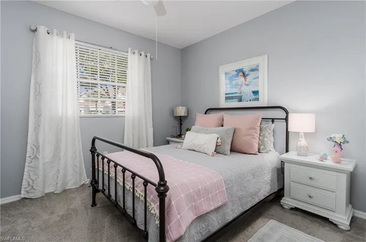 Carpeted bedroom featuring baseboards and a ceiling fan