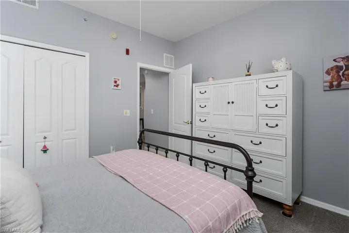 Bedroom featuring dark colored carpet and a closet