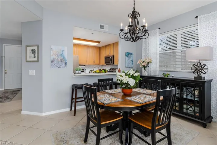Dining area with light tile patterned flooring and a chandelier