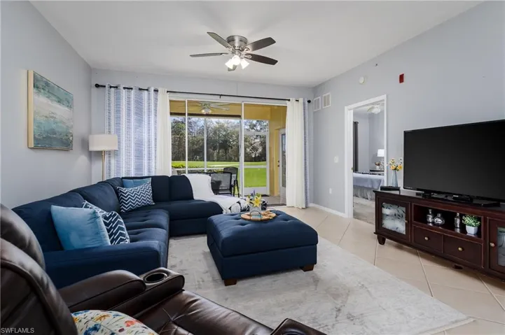 Living room with light tile patterned flooring and ceiling fan