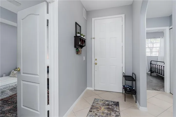 Foyer entrance with arched walkways and light tile patterned floors