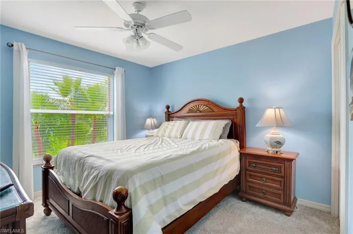 Carpeted bedroom featuring ceiling fan