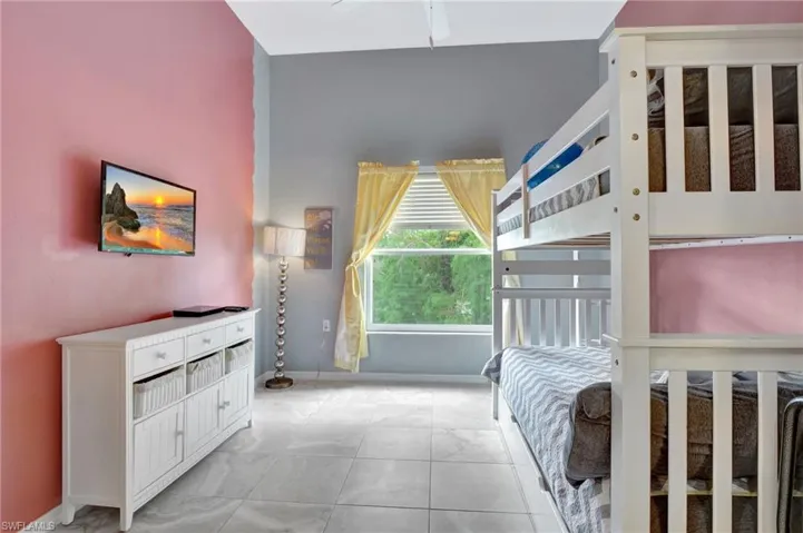 Bedroom with light tile patterned floors and ceiling fan
