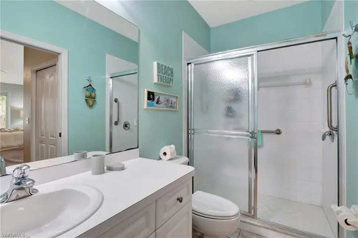 Bathroom with a shower with shower door, toilet, and vanity