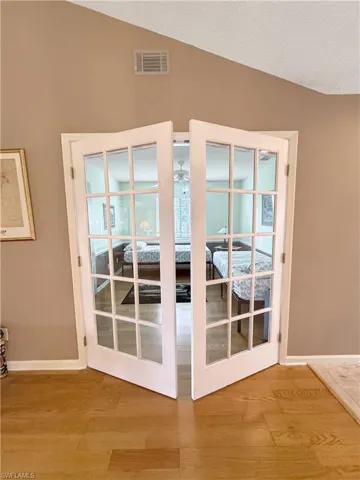 Doorway to outside with french doors, lofted ceiling, and hardwood / wood-style floors