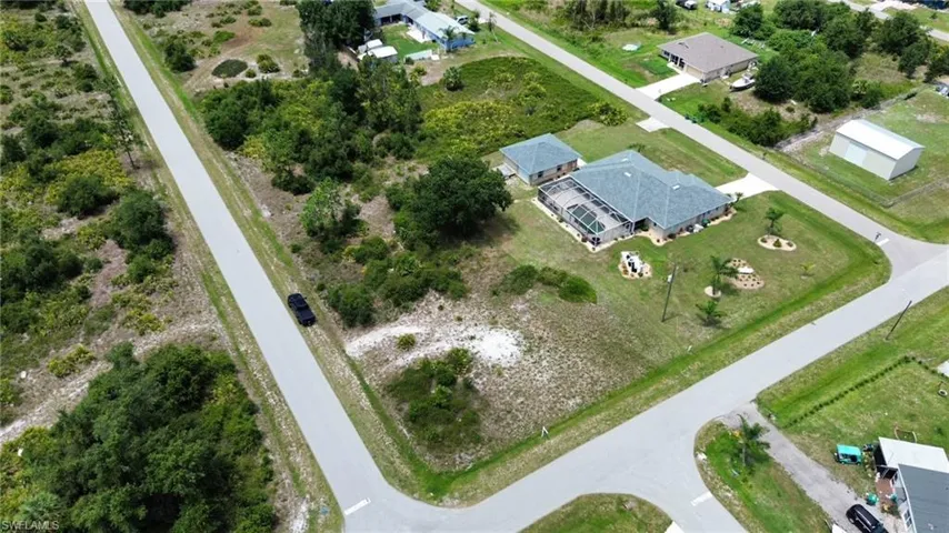 Expansive corner lot featuring a single-story residence with an attached garage and a detached accessory structure