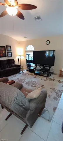 Tiled living room featuring ceiling fan