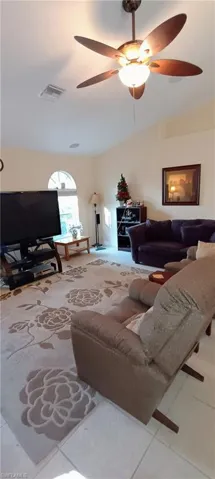 Living room with a ceiling fan and tile patterned flooring