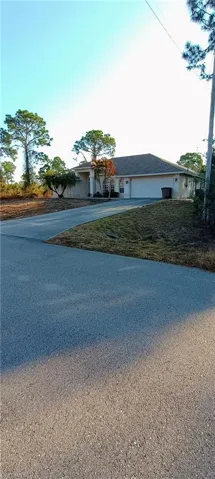 View of front of property with concrete driveway and an attached garage