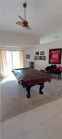 Recreation room with ceiling fan, light tile patterned flooring, and pool table