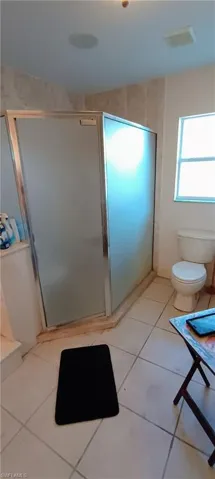 Full bathroom with a shower stall and light tile patterned floors