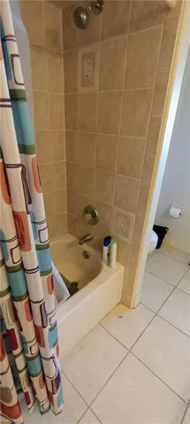 Pool Bath - Full bathroom with shower / bathtub combination with curtain and tile patterned floors