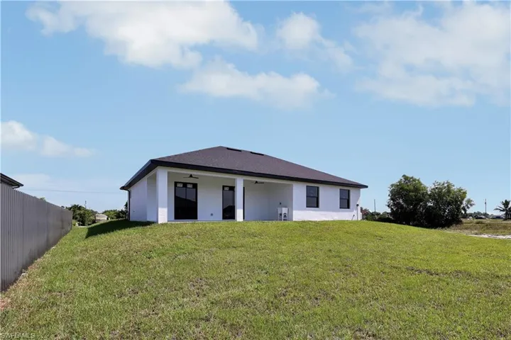 Back of house with a lawn